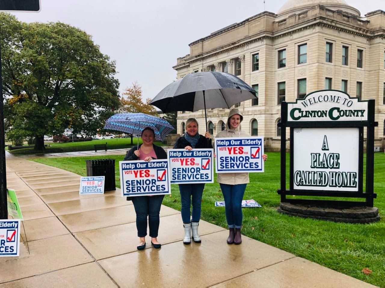 women holding signs in the rain