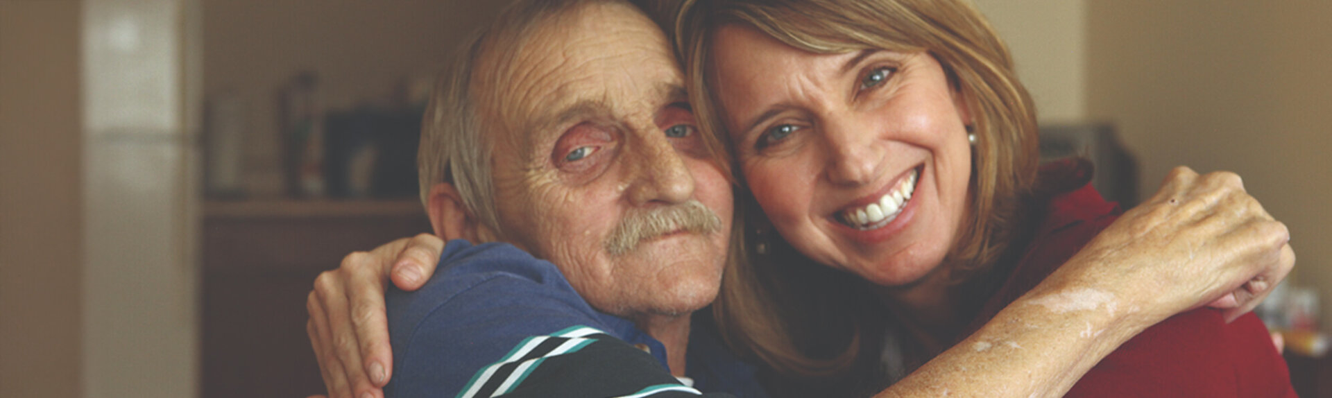 caregiver hugging senior man