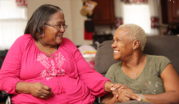 Caregiver holding senior woman's hand