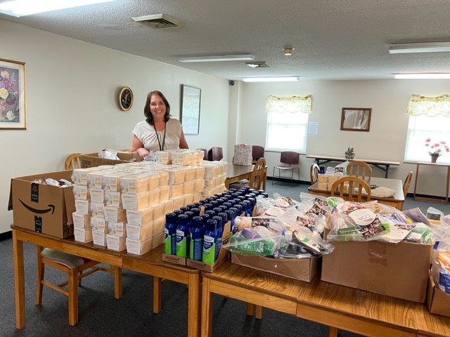 Woman stands with items for delivery