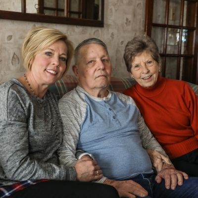 Family sitting on couch smiling