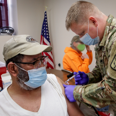 Senior man receives vaccination by army man