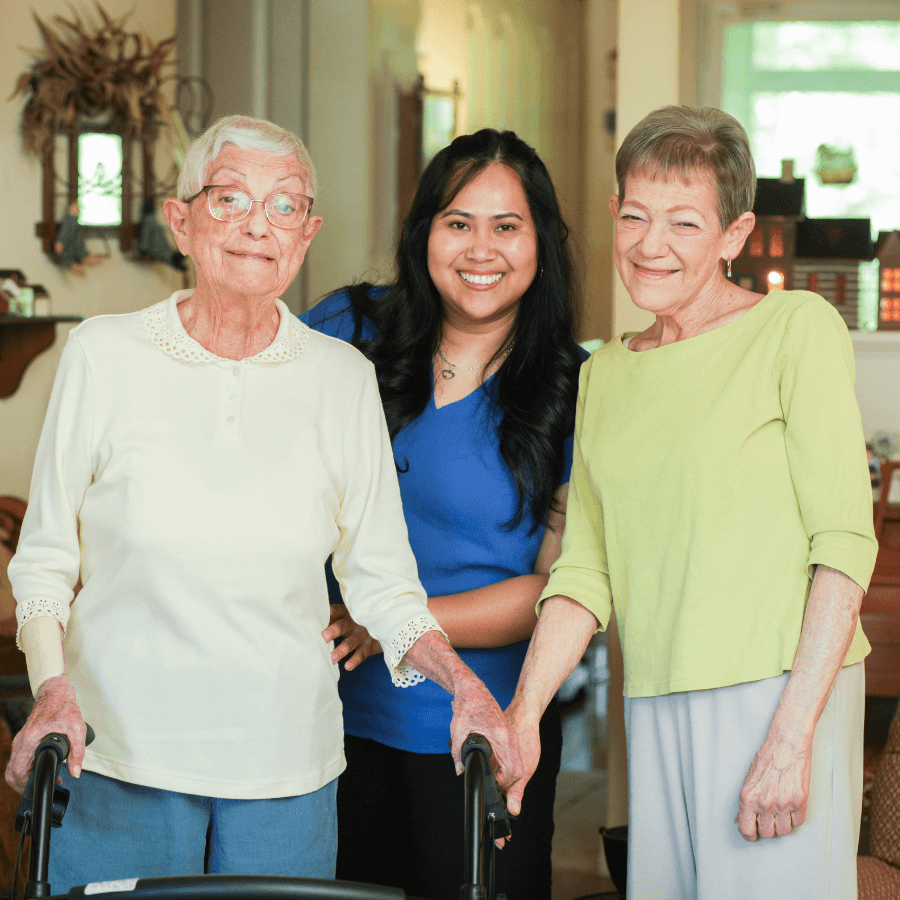 volunteer smiling with two seniors