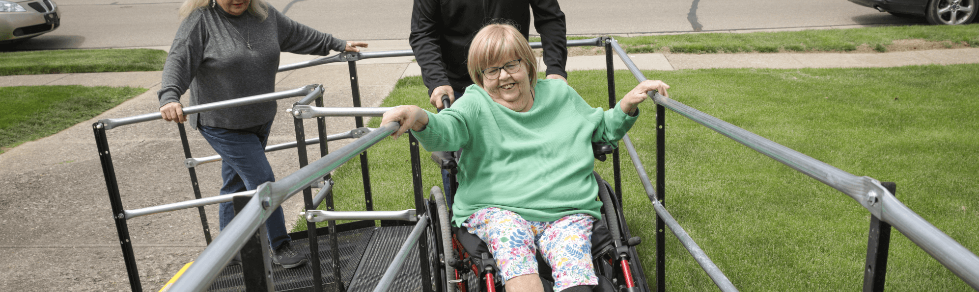 senior being pushed up wheelchair ramp