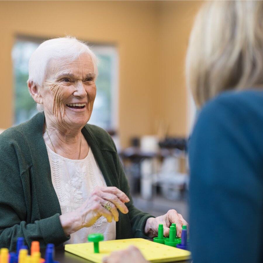 older adult woman doing an activity with another adult