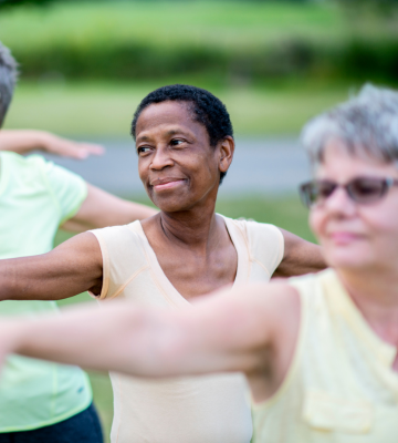 Older adult females doing tai chi outdoors